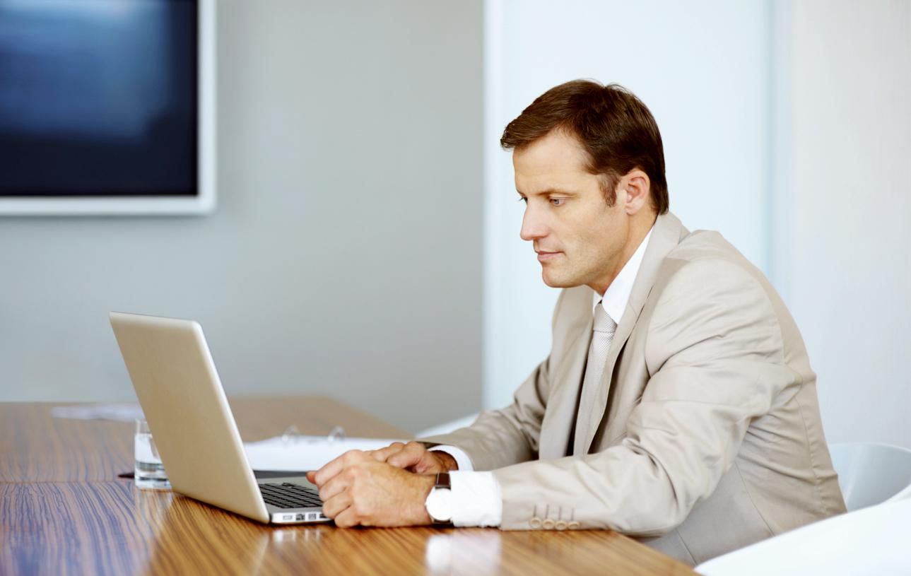 Executive working on laptop in boardroom