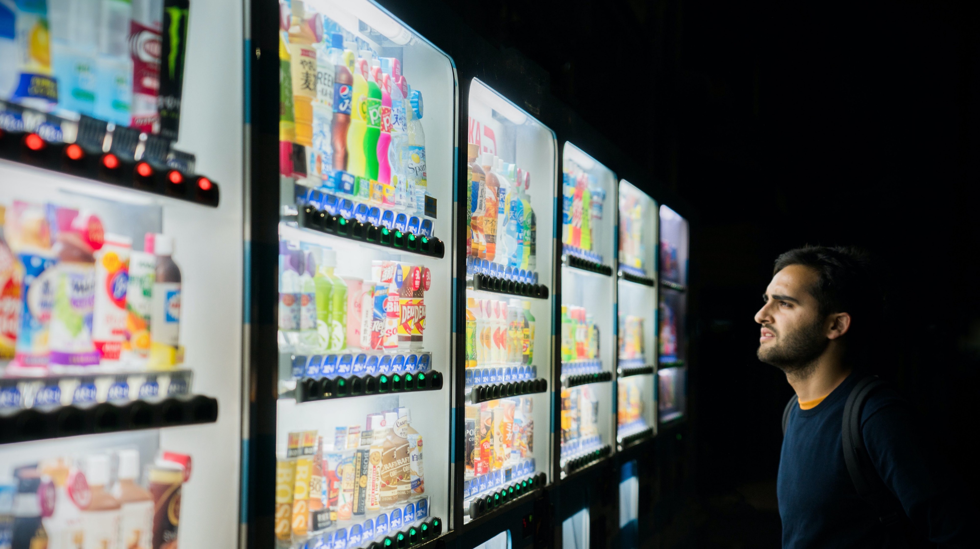 Man watching vending machines in the dark